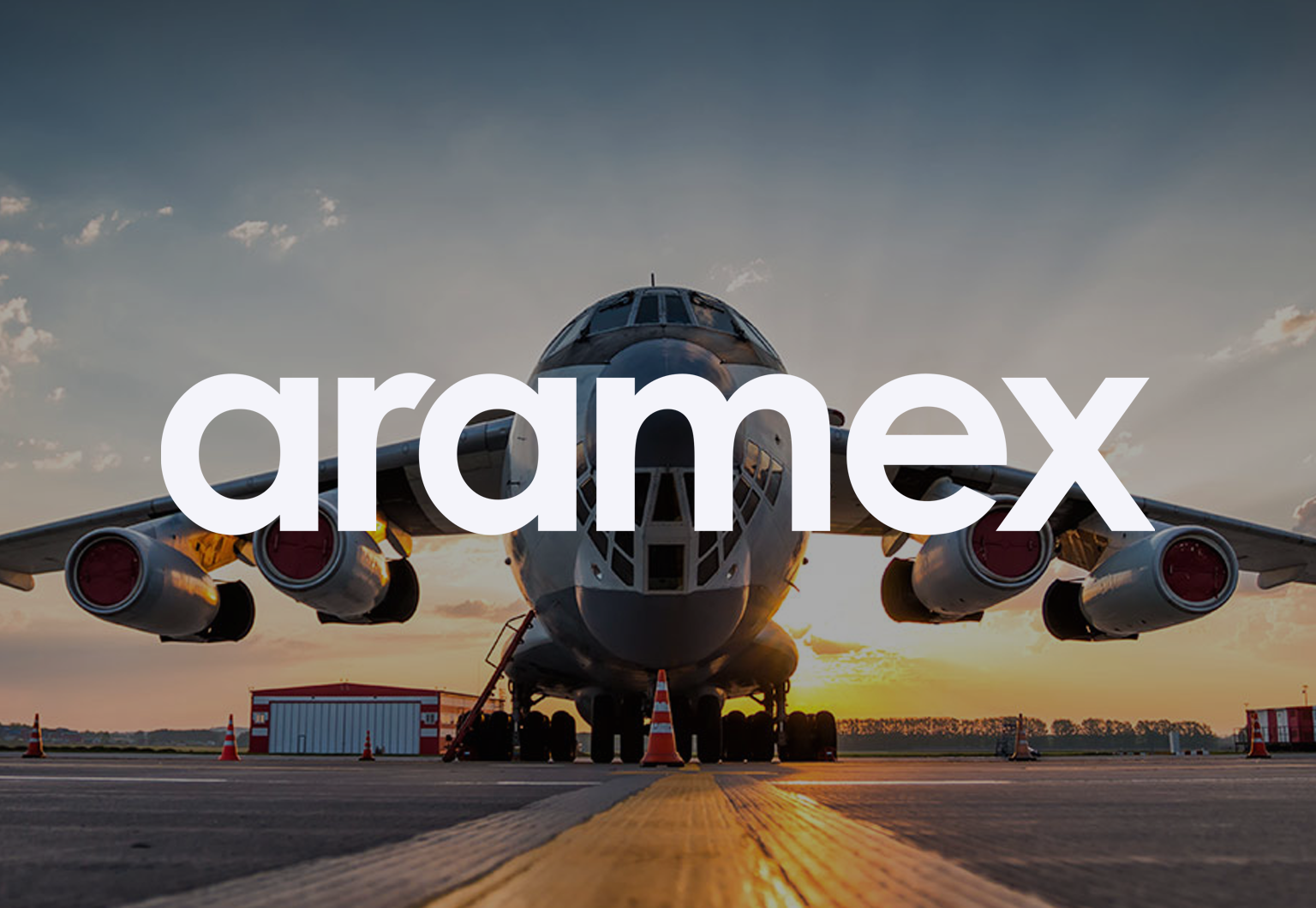 Aeroplane on tarmac with 'aramex' written over the top of the image
