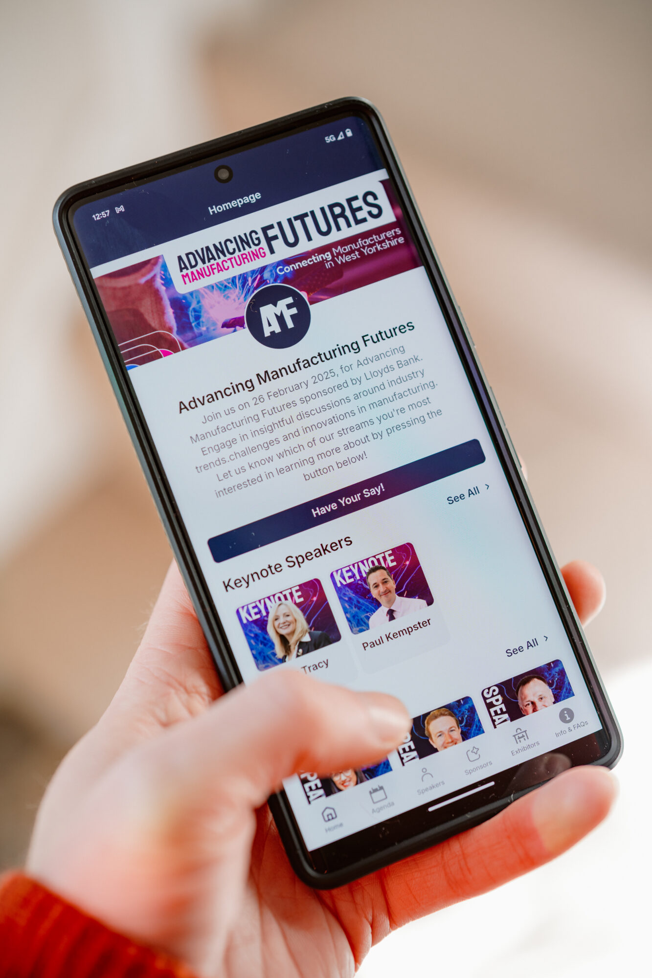A hand holding a phone showing the AMF app